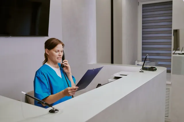 A medical administrator on the phone reviewing records