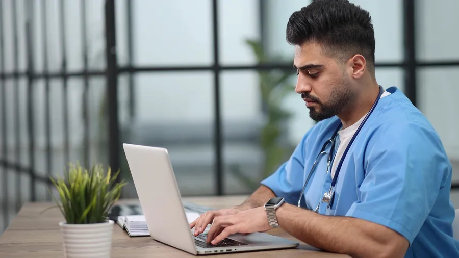 A clinician working through billing and administration at a desk